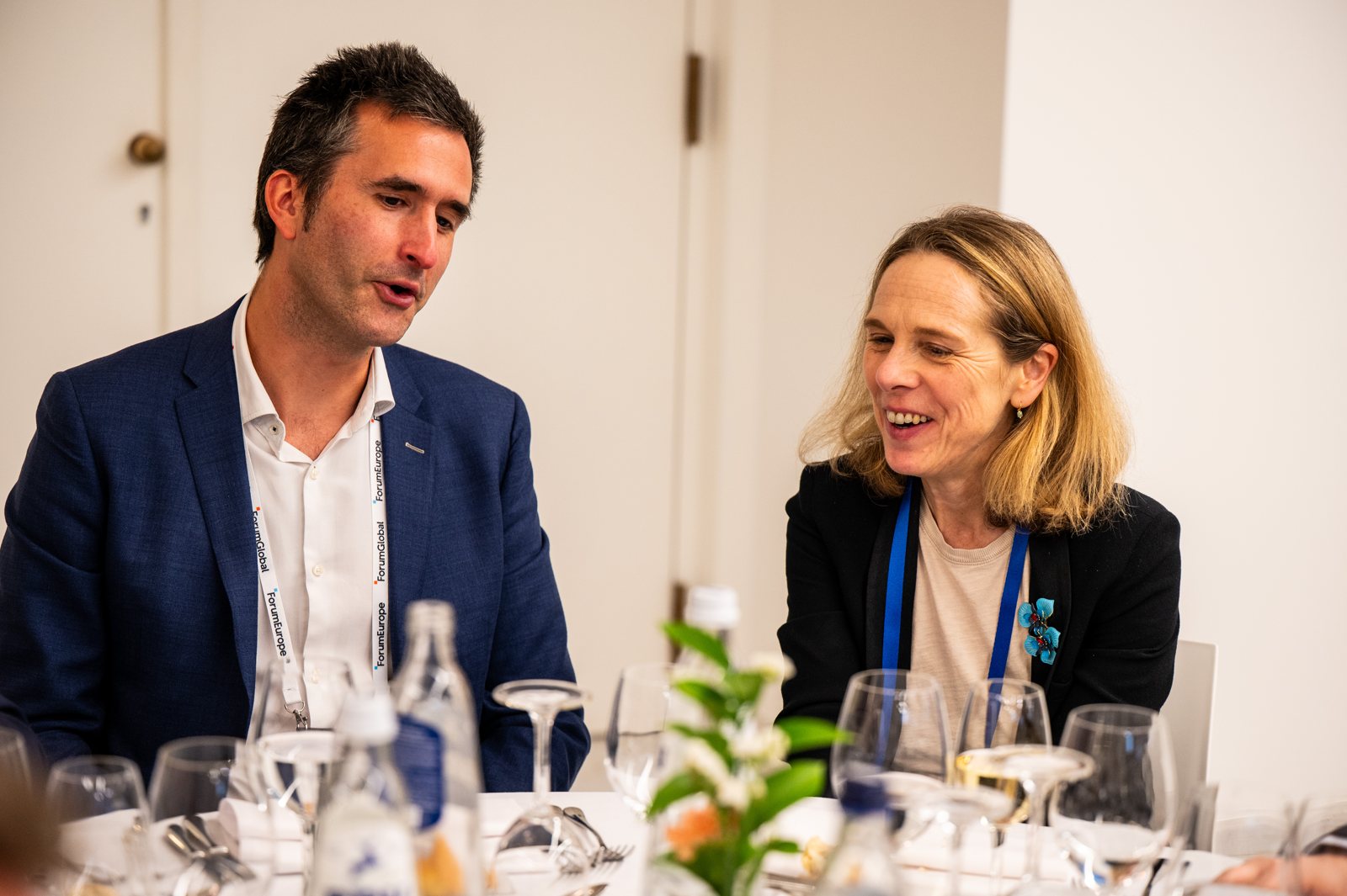 Two delegates in conversation over lunch, 2026
